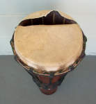 The torn drumhead of an ashiko drum.