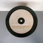 A torn doumbek drumhead painted to look somewhat like a bullseye.
