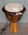 Stave djembe with an torn drum head.