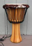 Stave jembe drum with an old ripped skin.