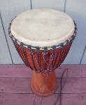 Djembe with a torn goat skin drum head.