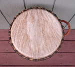 An African djembe hand drum with a torn goat skin drum head.