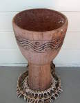 An old and faded djembe that has no drum head.