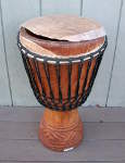 A djembe hand drum with a torn drum head.
