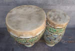 A set of Moroccan bongos with one skin torn.