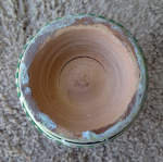 A large crack at the base of one of the clay shells of a set of bongos.