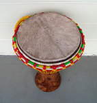 A djembe with a newly mounted goat skin drum head with new rope.