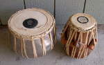 Old, dented tabla set with damaged parts.