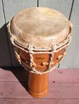 Stave djembe with a torn drum head.