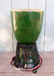 A green djembe that needs to be repaired.