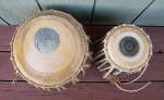 A tabla set with damaged pudis and strap.