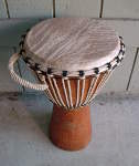 African djembe from Gambia with a ripped drum head.
