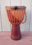 A fresh hairy goat skin with a fold over on a djembe.