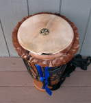 An ashiko hand drum with a torn drum head.