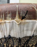 A skirted fish skin drum head with a tear.