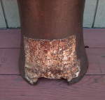 A metal patch at the base of the African peg drum.