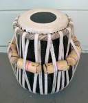 A tabla dayan with freshly installed drumhead and lacing.
