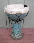 A ceramic doumbek with a torn drum head.