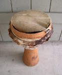African djembe hand drum with a torn skin and cracked drum shell.