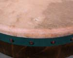 Closeup of a puncture on the drumskin of a bodhran.