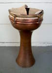 A tarnished copper darbuka that needs to have the skin replaced.