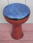 A ceramic doumbek with a fresh goat skin drumhead that's dyed blue.