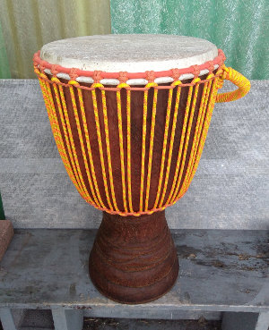 Djembe hand drum with yellow and orange rope and wrap.